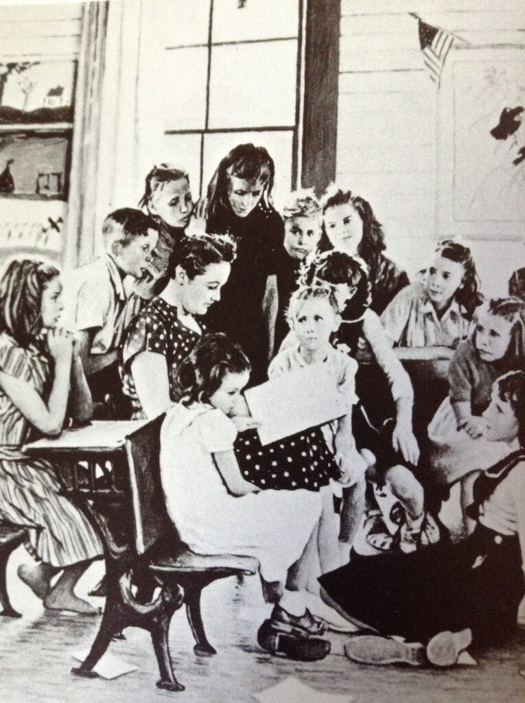 Children gathered around a woman reading book.