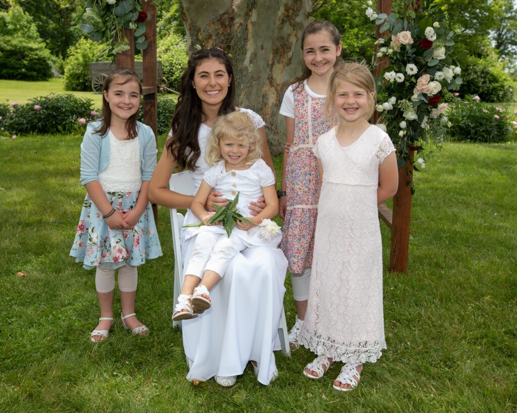 Woman and children smiling in a garden.