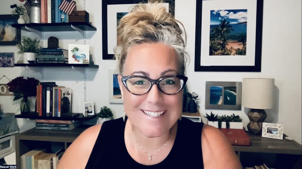 Smiling person in home office with shelves.